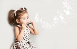 Cute little girl playing harmonica isolated on white. music education concept