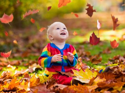 Kids play in autumn park. Children throwing yellow and red leaves.Baby with oak and maple leaf. Fall foliage. Family outdoor fun in autumn. Toddler kid or preschooler child in fall.